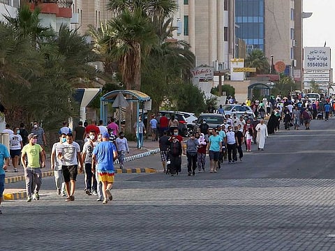 Mask-clad residents walk in a neighbourhood of Kuwait City on May 12, 2020, as authorities allowed people to exercise for two hours under a nationwide lockdown due to COVID-19.