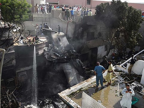 Firefighters spray water on the wreckage of the Pakistan International Airlines aircraft after it crashed on a residential area in Karachi.