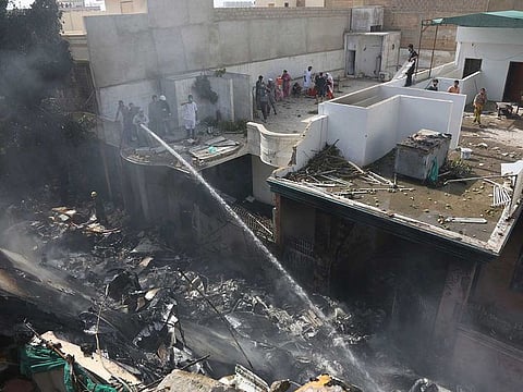 Fire brigade staff try to put out fire caused by plane crash in Karachi, Pakistan.