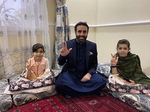Two Afghan sisters Farishta, 9 (right) and Nadira, 6, with Consul General of Afghanistan Masood Azizi, who visited the girls at their house in Sharjah and promised to reunite them with their parents stranded abroad.