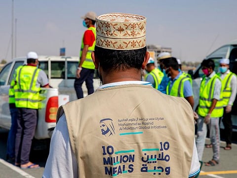 A meal distributor dons a 10 Million Meals gillet