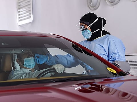 File photo: Paramedics taking swab sample at a SEHA drive through National Screening Center at Golf and Shooting club in Sharjah.