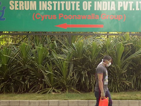 A man walks past a signpost of India's Serum Institute, the world's largest maker of vaccines, which is developing a vaccine against COVID-19 at its laboratory in Pune, India, May 18, 2020.