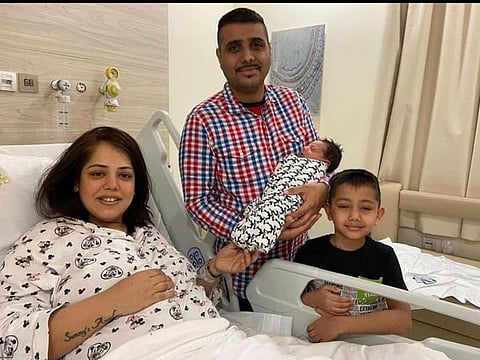 Sunny cradles his newborn as he poses for the camera with elder son Siddhant and wife Sanam at University Thumbay
