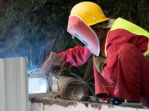 A worker performs welding works on a bridge in Beijing on May 14, 2020. As job losses surge, China is joining the United States and other governments in rolling out stimulus spending to revive its virus-battered economy.