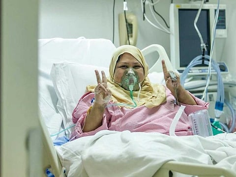 A nurse in Saudi Arabia who is undergoing treatment for the coronavirus flashes the V-sign at the hospital.