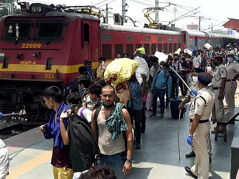 Migrants stand in a queue after getting off the Shramik Special train to board buses home, at Danapur station, during the nationwide lockdown in the wake of coronavirus pandemic, in Patna on Sunday.