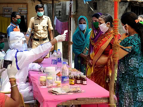 File photo: Healthcare workers check the temperature of residences of the slum area, in Mumbai.