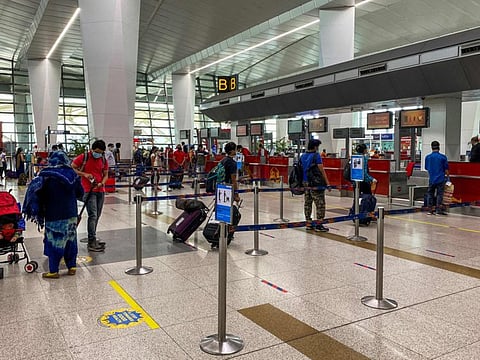 Passengers queue at Delhi Airport check-in on the first day of domestic flights resuming on Monday