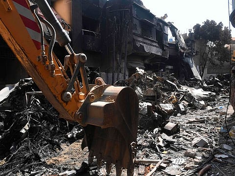 Security personnel walk over the wreckage of a plane at the site after a Pakistan International Airlines aircraft crashed in a residential area days before, in Karachi on May 24, 2020.