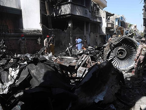 Security personnel stand beside the wreckage of a plane at the site after a Pakistan International Airlines aircraft crashed in a residential area days before, in Karachi on May 24. Ninety-seven people were killed and two survived when a passenger plane crashed into homes in Pakistan's southern city of Karachi.