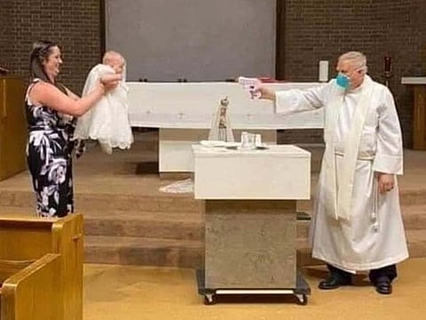 Priest uses water gun during baptism to maintain social distancing