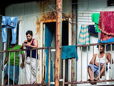 This photo taken on May 9, 2020 shows foreign workers from Bangladesh gathering in their accommodation block after being put under quarantine to contain the spread of the COVID-19 coronavirus, in Male.