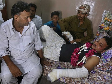 Relatives visit with Mohammad Zubair, a passenger who survived a plane crash, at his home in Karachi, Pakistan, Saturday, May 23, 2020. When the plane jolted violently, Zubair thought it was turbulence. Then the pilot came on the intercom to warn that the landing could be "troublesome." Moments later, the Pakistan International Airlines flight crashed into a crowded neighborhood near Karachi's international airport.