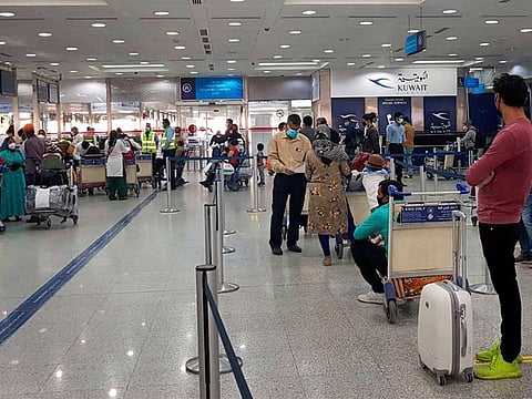 Stranded Indian nationals check-in at Kuwait International Airport to travel back home as part of the government's 'Vande Bharat' mission, amid ongoing coronavirus pandemic, in Kuwait on May 13.