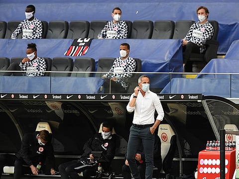 Eintracht Frankfurt coach Adi Hutter and players in the stands wearing protective face mask, as German football play resumes behind closed doors following the outbreak of the coronavirus disease.