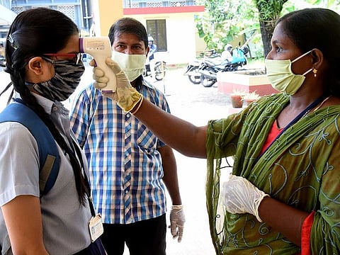 Students being screened as they arrive to take the SSLC Examination at a school in Kochi, Kerala.