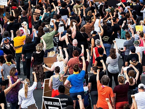 Protesters gather calling for justice for George Floyd on Tuesday, May 26, 2020, in Minneapolis. Four Minneapolis officers involved in the arrest of Floyd, a black man who died in police custody, were fired Tuesday, hours after a bystander's video showed an officer kneeling on the handcuffed man’s neck, even after he pleaded that he could not breathe and stopped moving.