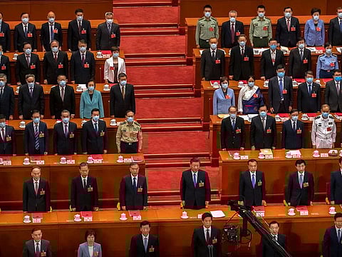 Chinese President Xi Jinping, second row at center, and other Chinese leaders and delegates stand during the closing session of China's National People's Congress (NPC) at the Great Hall of the People in Beijing, Thursday, May 28, 2020. China's ceremonial legislature has endorsed a national security law for Hong Kong that has strained relations with the United States and Britain.