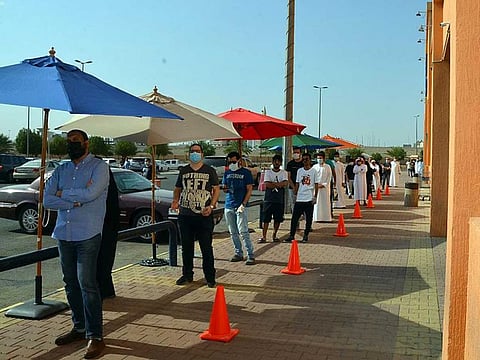 Shoppers queue up outside a mall in the Saudi city of Medina Thursday.
