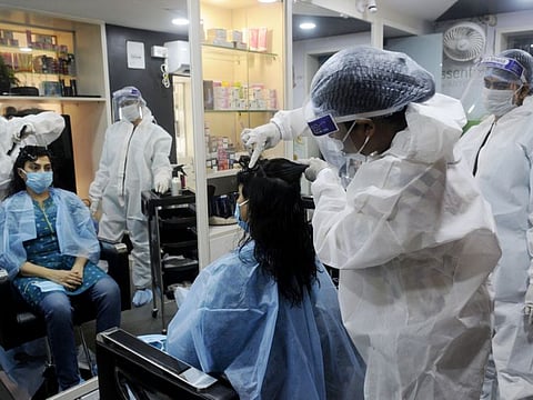 Women wearing PPE kits working at a Beauty parlour, in Kolkata on Saturday.