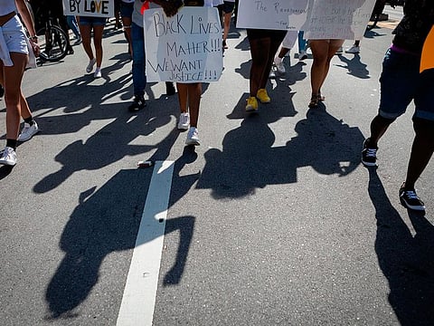 Protestors march during a rally in Coral Gables, Florida on May 30, 2020 in response to the recent death of George Floyd, an unarmed black man who died while while being arrested and pinned to the ground by the knee of a Minneapolis police officer.