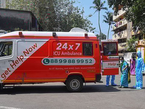 HelpNow ambulance staff wearing protective gear escort a patient (3L) aboard an ambulance before driving to a government hospital, after the government eased a nationwide lockdown imposed as a preventive measure against the COVID-19 coronavirus, in Mumbai