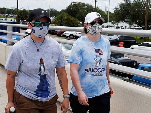 People wearing protective face masks arrive to watch the launch of a SpaceX Falcon 9 rocket and Crew Dragon spacecraft from the Kennedy Space Centre, in Cape Canaveral, Florida, US on May 30, 2020.