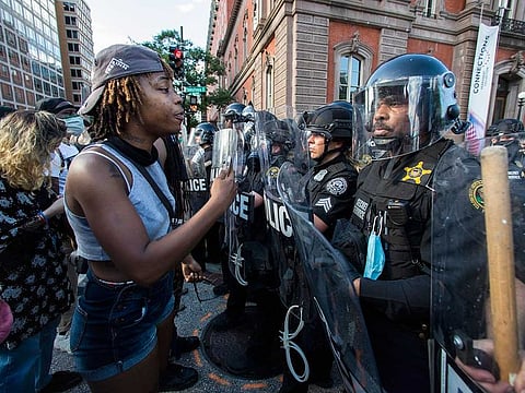 Demonstrators talk to police in riot gear as they protest the death of George Floyd near the White House in Washington. Floyd died after being restrained by Minneapolis police officers on Memorial Day.