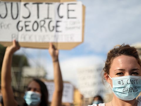 People wear protective face masks during a protest against the death in Minneapolis police custody of George Floyd, in front of a U.S. consulate, in Barcelona, Spain June 1, 2020.