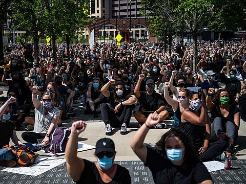People raise their hands during a protest in Minneapolis.