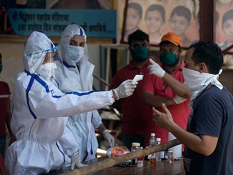 Medics check the temperature of residences of Munshi Compound, Gulshan Nagar during a nationwide lockdown to control the spread of the Coronavirus (COVID-19) pandemic, in Mumbai on Sunday.