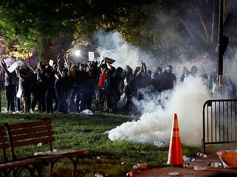 Tear gas billows as demonstrators gather in Lafayette Park to protest the death of George Floyd, Sunday, May 31, 2020, near the White House in Washington.
