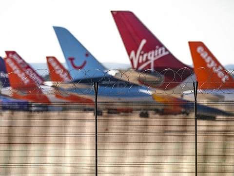 Razor wire stands on a security fence near grounded passenger aircraft on the tarmac at Manchester Airport, operated by Manchester Airport Plc, in Manchester, U.K., on Monday, June 1, 2020.