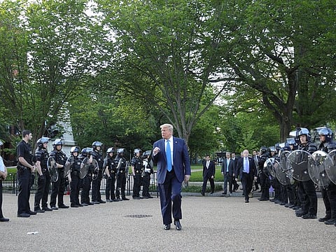 US President Donald Trump pumps his fist toward police as he walks between lines of riot police in Lafayette Park across from the White House while walking to St John's Church for a photo opportunity during ongoing protests over racial inequality in the wake of the death of George Floyd while in Minneapolis police custody, at the White House in Washington, U.S., June 1, 2020.