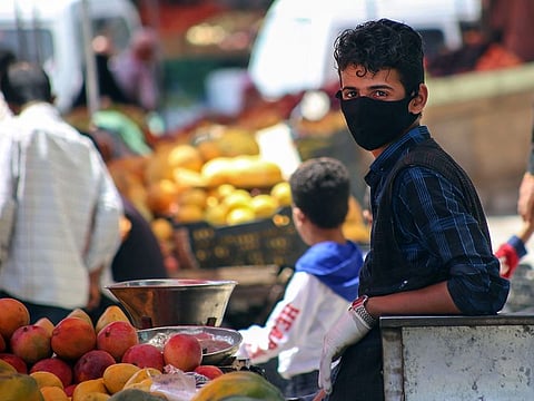 A Yemeni youth wearing a protective mask sells fruits at a street market in Yemen's third city of Taez, on June 1, 2020 amid the novel coronavirus pandemic crisis. Yemen is wracked by a war which has killed tens of thousands of people and led to the world's worst humanitarian crisis, according to the United Nations. The war between Huthi rebels and pro-government forces escalated in 2015 when a Saudi-led military coalition intervened against the rebels who control large parts of Yemen including the capital Sanaa.