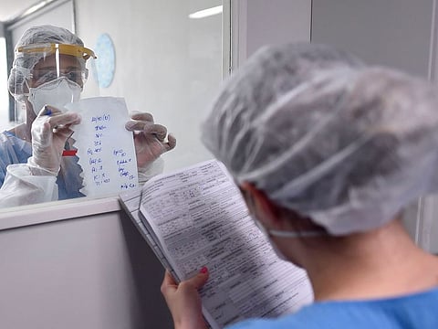 A health professional wearing full PPE (personal protective equipment) as a precautionary measure against the novel coronavirus, passes information about a COVID-19 patient through a window at the Intensive Care Unit (ICU) of the Santa Casa hospital in Belo Horizonte, state of Minas Gerais, Brazil, on June 1, 2020. The pandemic has killed 373,439 people worldwide since it surfaced in China late last year, according to an AFP tally at 1900 GMT on Monday, based on official sources. In a grim new landmark, infections in Latin America and the Caribbean surge past one million.