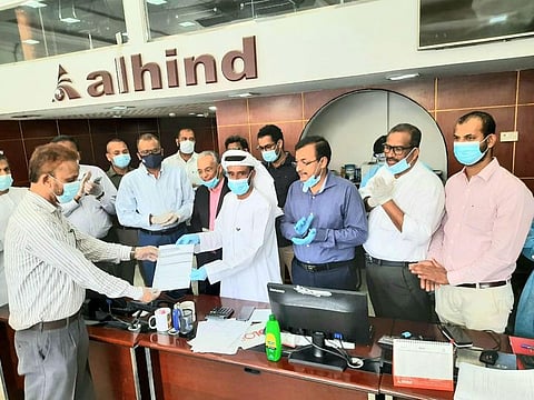 KMCC officials distribute tickets for its first two chartered flights to repatriate stranded community members to Kerala.