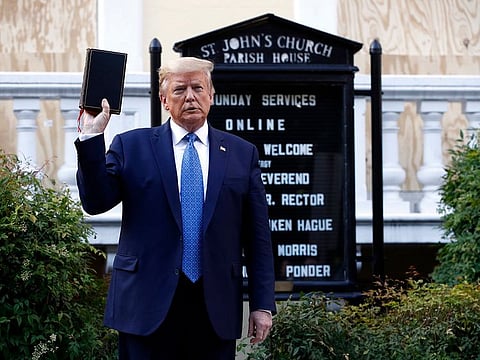 President Donald Trump holds a Bible as he visits outside St. John's Church across Lafayette Park from the White House Monday, June 1, 2020, in Washington.