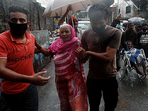 People help elderly citizens during an evacuation from a slum off the coast of the Arabian sea as cyclone Nisarga makes its landfall on the outskirts of the city, in Mumbai, India, June 3, 2020.