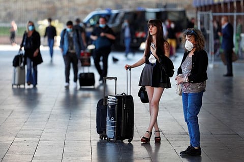 A woman with her luggage stands outside Rome's Termini train station, as Italy relaxed more of its restrictions and allowed free movement across the country to unwind its rigid lockdown due to the coronavirus pandemic.