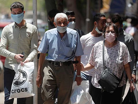 People wearing face masks to prevent the spread of the coronavirus disease (COVID-19) walk in Cairo.