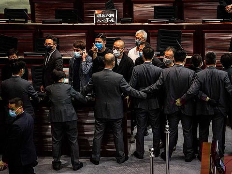 Protesting pro-democracy lawmakers (facing) are blocked off by security (bottom) during a debate on a law that bans insulting China's national anthem, during a session of the Legislative Council (Legco) in Hong Kong on June 4, 2020.