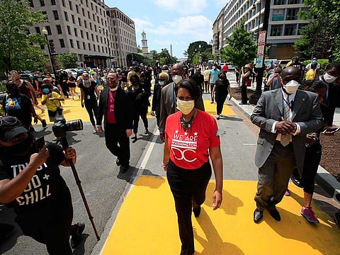 District of Columbia Mayor Muriel Bowser walks on the street leading to the White House after the words Black Lives Matter were painted in enormous bright yellow letters on the street by city workers and activists.