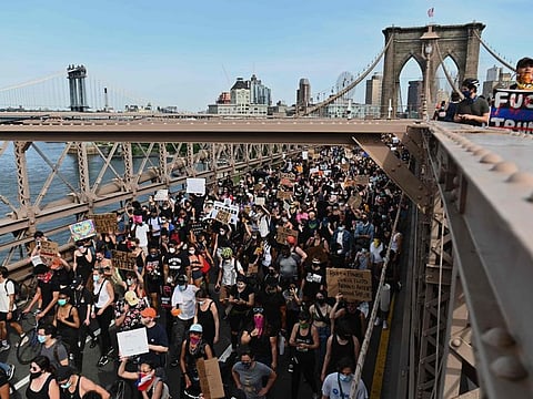 Thousands of protesters march over the Brooklyn Bridge to demonstrate against the death of George Floyd on June 4, 2020 in New York. On May 25, 2020, Floyd, a 46-year-old black man suspected of passing a counterfeit $20 bill, died in Minneapolis after Derek Chauvin, a white police officer, pressed his knee to Floyd's neck for almost nine minutes.