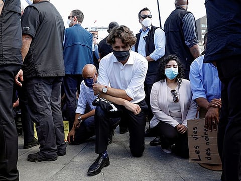 Canada's Prime Minister Justin Trudeau wears a mask as he takes a knee during a rally against the death in Minneapolis police custody of George Floyd, on Parliament Hill, in Ottawa, Ontario, Canada.