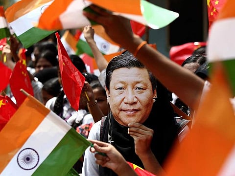 An Indian schoolgirl wears a face mask of Chinese President Xi Jinping to welcome him on October 10, 2019, the eve of his visit in Chennai, India.