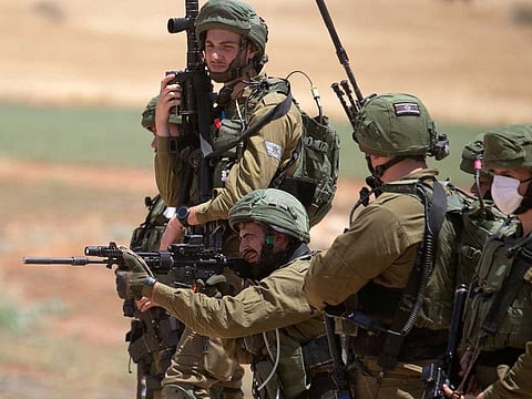 A member of the Israeli security forces fires towards Palestinian demonstrators during a protest against Israel's plan to annex parts of the occupied West Bank, near the village of Atuf in the Jordan Valley on June 5, 2020