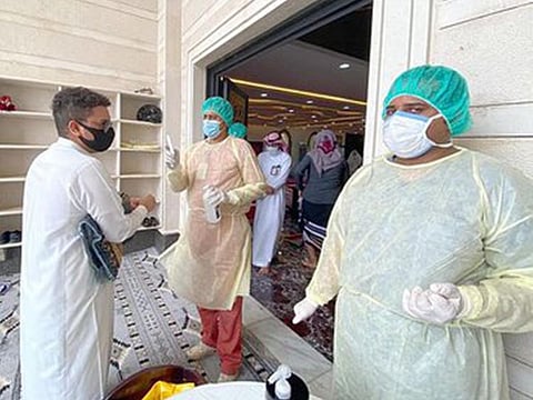 Medics check worshippers' temperatures at a mosque in the governorate of Sabya in south-western Saudi Arabia