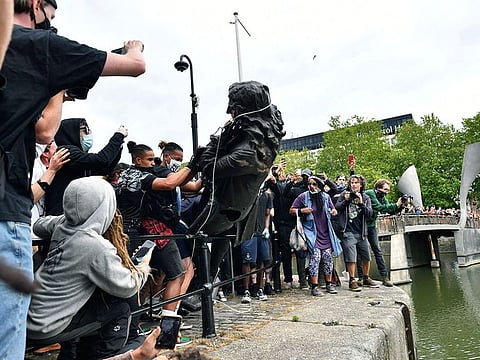 Protesters throw a statue of slave trader Edward Colston into the Bristol harbour, during a Black Lives Matter protest rally, in Bristol, England, Sunday June 7, 2020, in response to the recent killing of George Floyd by police officers in Minneapolis, USA, that has led to protests in many countries and across the US.